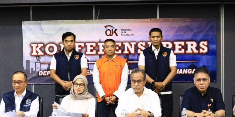 Adrian Gunadi masih sempat tersenyum saat ekspos kasus yang menjeratnya dan menjadi buronan. (Foto OJK)