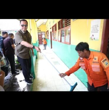 Capiton FotoWalikota Serang Budi Rustandi menguras genangan air di koridor SD Negeri Ciputat, Kelurahan Kaligandu, Kecamatan Serang Kota Serang, Kamis 29 Januari 2026. (Dokumentasi Prokopim Setda Kota Serang untuk Bantenraya.com)