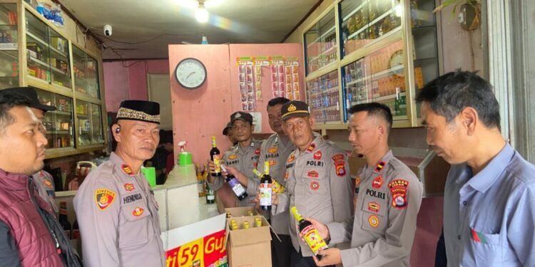 Polisi tengah menyita botol miras pada salah satu waring jamu di Kabupaten Lebak, Selasa, 17 Februari 2026.