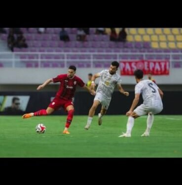 Capiton Foto Pemain Persis Solo FC (jersey merah) mendapat kawalan dua pemain Madura United FC dalam laga pekan ke-21 BRI Super League 2025-2026. (Instagram @persisofficial)