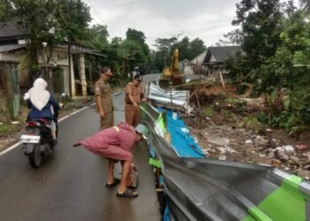 Camat Munjul Hasim meninjau akses Jalan Raya Munjul-Picung yang mengalami longsor di Kampung Cibeureum, Desa Sukasaba, Kecamatan Munjul, Kabupaten Pandeglang, Selasa 10 Februari 2026. (Dokumentasi Bantenraya.com)