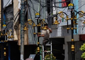 Pekerja memperbaiki lampu Royal Baroe di Kota Serang. Pemprov Banten mendorong perusahaan menaikkan standar Keselamatan dan Kesehatan Kerja (K3) Nasional tahun 2026. (Doni Kurniawan/ Bantenraya.com)