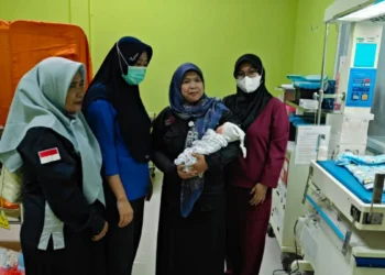 Ketua Komnas PA Kabupaten Serang Kuratu Akyun (dua dari kanan) menggendong bayi yang dibuang di Desa Pedaleman, kecamatan Tanara, Selasa 10 Februari 2026. (Andika/Bantenraya.com)