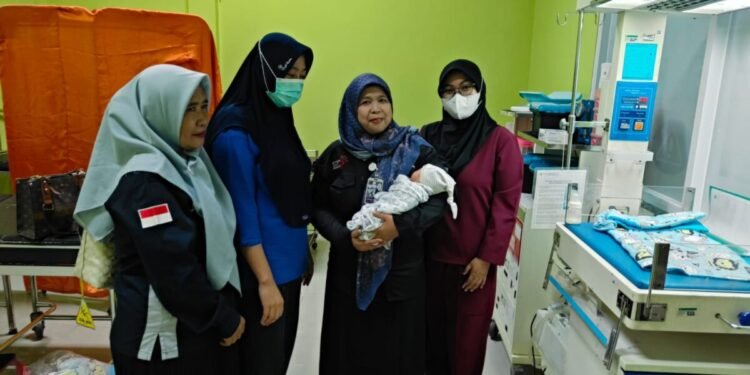 Ketua Komnas PA Kabupaten Serang Kuratu Akyun (dua dari kanan) menggendong bayi yang dibuang di Desa Pedaleman, kecamatan Tanara, Selasa 10 Februari 2026. (Andika/Bantenraya.com)