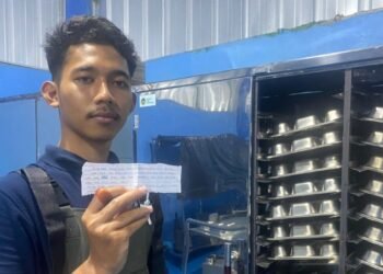 Petugas Dapur SPPG Yayasan Sukaratu 6, Kecamatan Majasari, Kabupaten Pandeglang, memperlihatkan selembar surat cinta dari siswa yang terselip dalam ompreng MBG, Rabu 11 Februari 2026. (Dokumentasi Bantenraya.com)