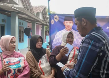 Ketua DPC Partai Demokrat Kabupaten Serang Azwar Anas membagikan bantuan beras dan uang tunai kepada warga di Desa Sentul, Kecamatan Kragilan, Selasa 17 Februari 2026. (Andika/Bantenraya.com)