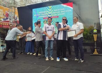 Walikota Serang Budi Rustandi didampingi Wakil Walikota Serang Nur Agis Aulia memberikan penghargaan kepada OPD yang telah mendukung 13 program Budi-Agis di 1 tahun kinerjanya pada peresmian Kawasan Royal Baroe, Kota Serang, Jumat 20 Februari 2026. (Harir Baldan/Bantenraya.com)