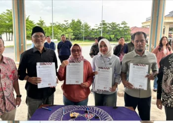 Para pegawai Perumdam Tirta Madani Kota Serang tunjukkan dokumen pakta integritas didampingi Direktur Arif Setiawan (kiri) dan Sekretaris Dewan Pengawas Haris Firmandoko di halaman kantor Perumdam Tirta Madani Kota Serang, Jumat 20 Februari 2026. (Dokumentasi Perumdam Tirta Madani Kota Serang untuk Bantenraya.com)