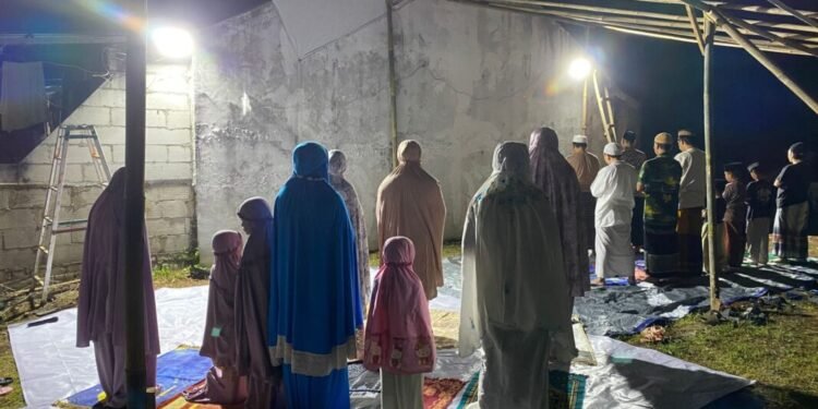 Para warga Perumahan Bukit Cinangka, Kabupaten Serang melaksanakan ibadah salat tarawih di lahan kosong, pada Minggu 22 Februari 2026. (Andika/Bantenraya.com)