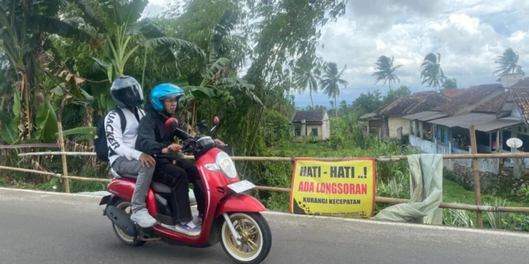 Pengendara melintas di kawasan tebing Jalan Raya Mengger-Mandalawangi di Desa Kadubungbang, dan Desa Kadumadang, Kecamatan Cimanuk, Kabupaten Pandeglang, yang rawan longsor, Senin (9/2). (Yanadi/Bantenraya)