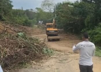 Tanah yang menutup akses Jalan Raya Batuhideng, Tanjung Lesung-Sumur, Kabupaten Pandeglang, dibersihkan alat berat, Rabu (25/2). (Yanadi/bantenraya)
