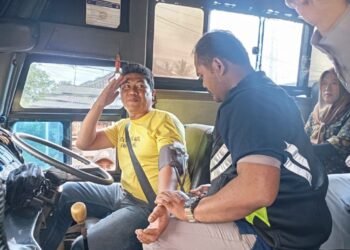 Petugas Dokkes Polres Pandeglang memberikan pelayanan cek kesehatan gratis kepada salah satu sopir angkutan umum, Senin (9/2).