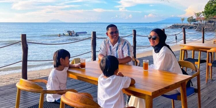 Suasana sebuah keluarga saat menikmati momen bersantai melihat pemandangan sunset ditemani deburan ombak di Harumi Kafe and Resto. (Dok/Hiromi Anyer)