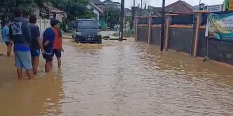 Warga Desa Margagiri, Kecamatan Banjir melintasi banjir yang terjadi pada Minggu 8 Maret 2026. (Andika/Bantenraya)