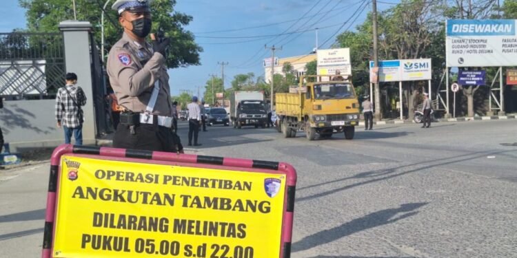 Polisi saat berjaga mengawadi truk tambang di ruas jalan Bojonegara, Kabupaten Serang.