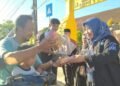 Kepala SMP Negeri 5 Kota Serang Ita Cahyawati membagikan takjil gratis kepada warga pengendara sepeda motor, Jumat 13 Maret 2026. Berbagi takjil di bulan Ramadan dalam rangka menanamkan nilai kepedulian sosial bagi siswa-siswinya. (Harir Baldan/Bantenraya.com)