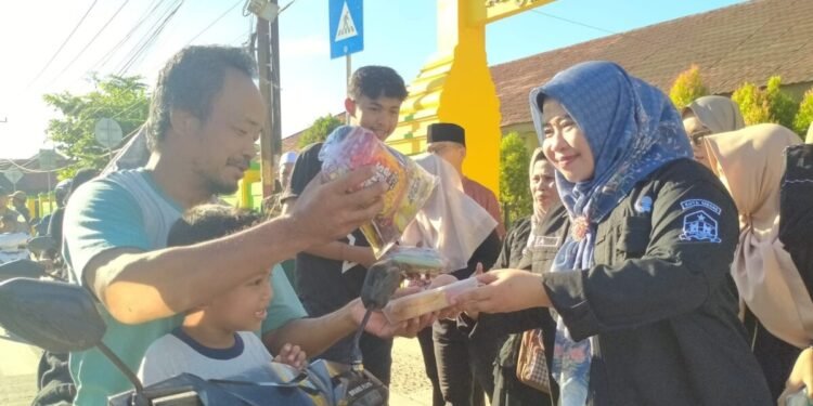 Kepala SMP Negeri 5 Kota Serang Ita Cahyawati membagikan takjil gratis kepada warga pengendara sepeda motor, Jumat 13 Maret 2026. Berbagi takjil di bulan Ramadan dalam rangka menanamkan nilai kepedulian sosial bagi siswa-siswinya. (Harir Baldan/Bantenraya.com)