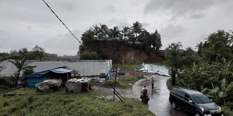 Petugas kepolisian meninjau Dapur MBG mengalami rusak sedang pada bagian atap karena tertiup angin kencang di Desa Mancak, Kecamatan Mancak, Jumat 27 Februari 2026. (Andika/Bantenraya)
