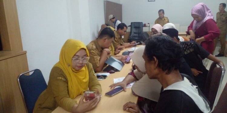  Petugas Diskominfo Cilegon mengarahkan warga untuk penfataran online mudik gratis, Senin (9/3). (Uri/Bantenraya)